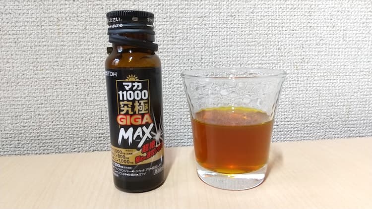 マカ11000究極GIGAMAXの瓶とグラスに注いだ液体